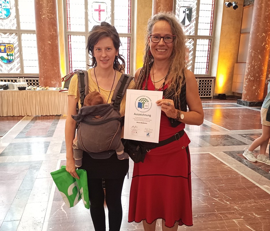 Auf dem Bild sind Mitarbeiterinnen der meco Akademie bei der Verleihung der Auszeichnung „Internationale Nachhaltigkeitsschule – Umweltschule in Europa“ zu sehen