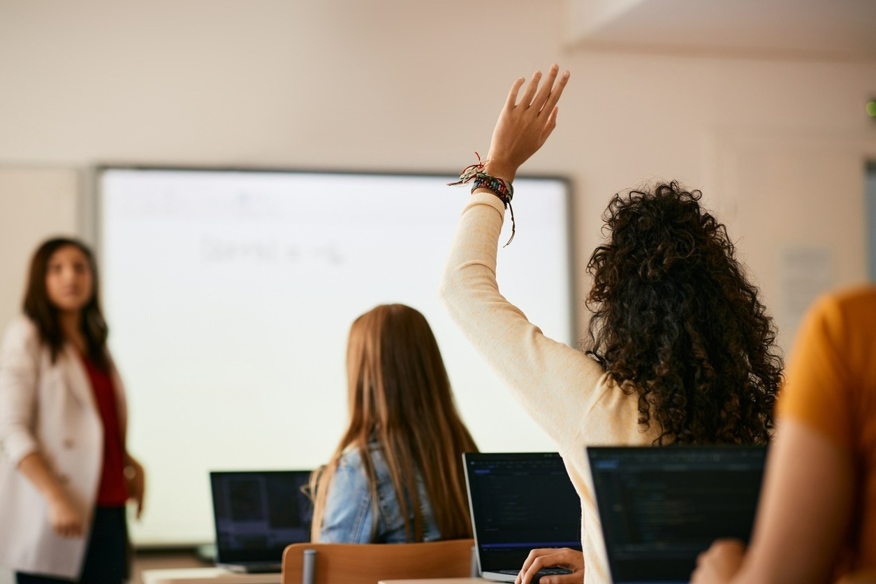 Schulungsraum mit Studierenden und Lehrkraft vor einem Smartboard.